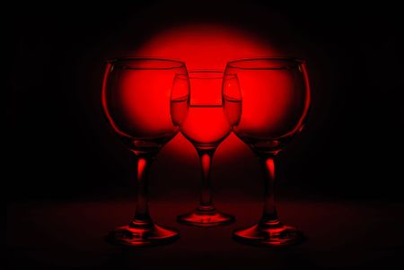 Three wine glasses on red spot backgroundの写真素材