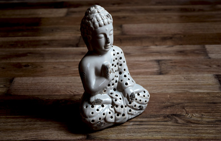Buddha sitting on the wooden floor, the god of love sculpture ornamentの写真素材
