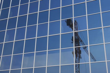 Building crane in the modern building glasses.の写真素材