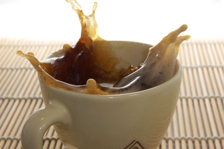 Dropping sugar into the coffee cup, white background, isolated.の写真素材