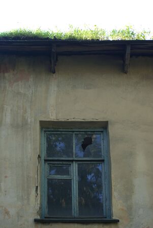 Old andoned house with grass on the roof and crashed windows.の写真素材