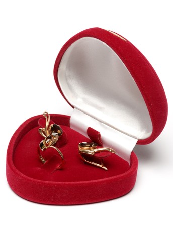 Pair of golden earrings and ring in the red box, isolated.の写真素材