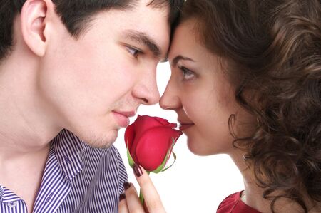 Closeup portrait of beautiful sexual couple with red rose isolated over white backgroundの写真素材