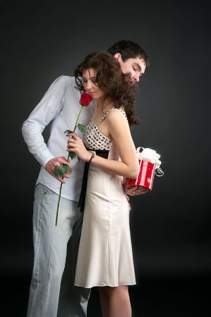 Happy young couple with gift and red rose isolated on a white background.の写真素材