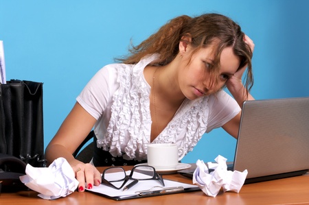 Beautiful young employer looking at laptop with troubled expression の写真素材