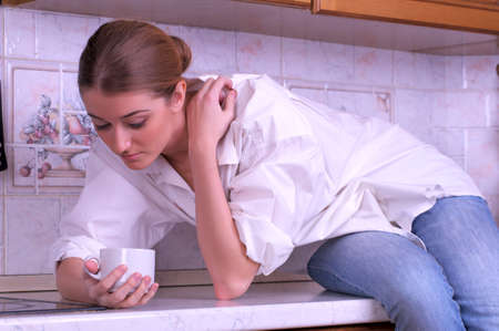 Sensual female is drinking coffee in the kitchenの写真素材