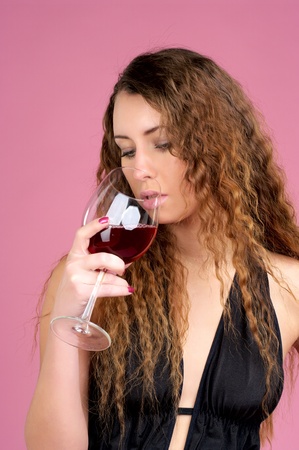 Beautiful woman with glass of red wine over white backgroundの写真素材