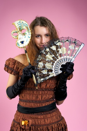 Beautiful young woman in evening gown with carnival maskの写真素材