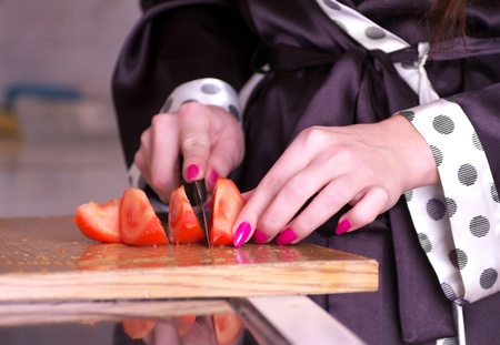 Closeup view of female hands cutting tomatoの写真素材