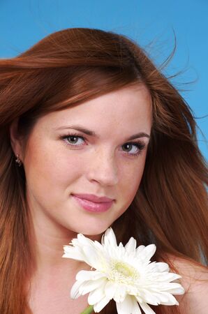 Closeup portrait of beautiful cacuacsian woman with white flowerの写真素材