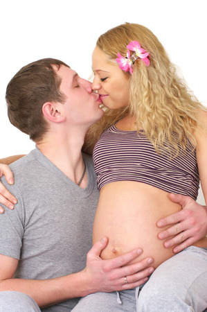 Portrait of pregnant couple kissing each otherの写真素材