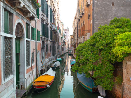 Empty Venice canal with boats moored near the building walls. Venice, Italy.のeditorial素材