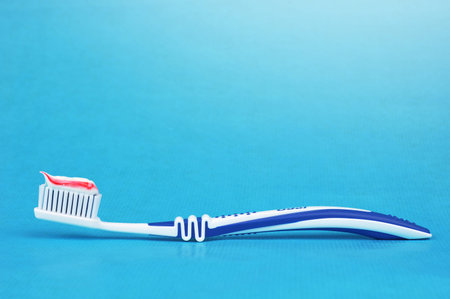 Toothbrush with toothpaste on a blue background