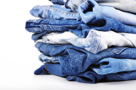 Stack of blue jeans isolated on a white backgroundの写真素材
