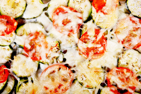 Tomatoes and zucchini baked with cheese in an ovenproof dishの写真素材