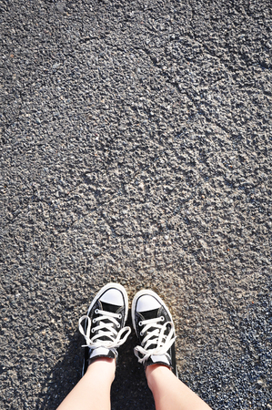 A pair of black canvas shoes on the roadの写真素材