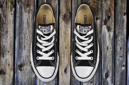 CHLUMCANY, CZECH REPUBLIC, MARCH 27, 2015: Black low Converse shoes on wooden planksの写真素材