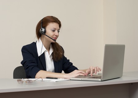 Business woman with laptop and headsetの写真素材