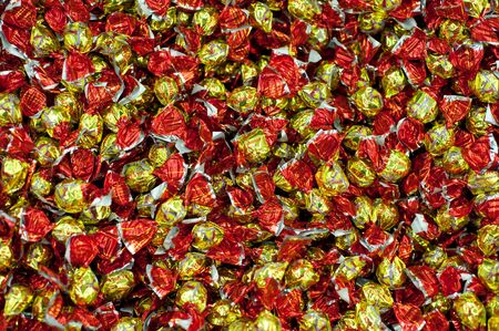 Many candies in red and yellow wrappingの写真素材
