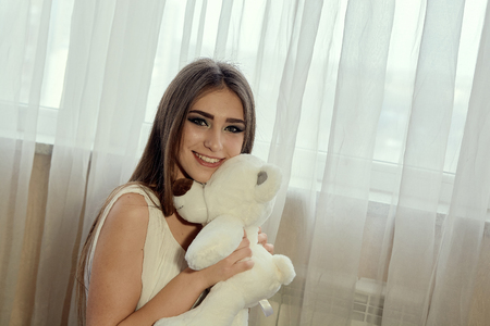 Girl with teddy bear for lifestyle design. Young caucasian model. Beautiful woman face. Beautiful smiling young woman.の写真素材