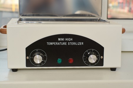 Mini high temperature sterelizer. Medical equipment healthcare. Modern medical technology concept. Modern hospital. Close-up sterilizer for manicure tools.の写真素材