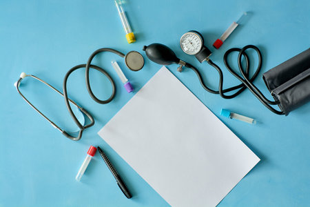 White sheet paper with black pen and phonendoscope stethoscope, sphygmomanometer, vacuum...
