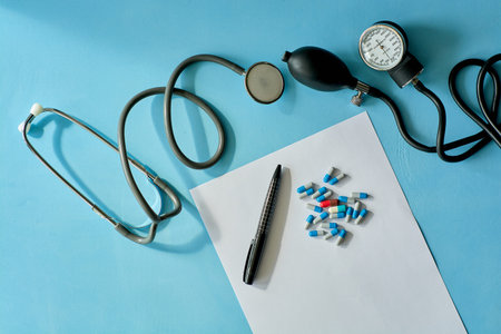 White sheet paper with black pen and colored different pills, capsules, phonendoscope stethoscope,...