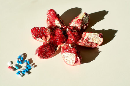 Garnet. Tablets and capsules, pills. The concept of a healthy life. Ripe red juicy pomegranate and...