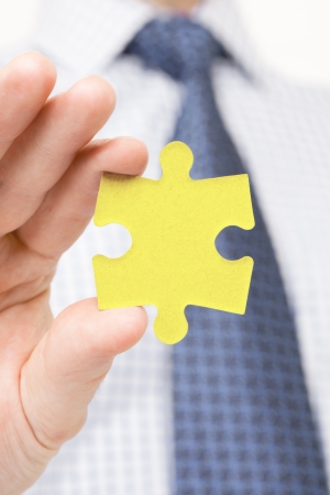 Male holding puzzle piece in one handの写真素材