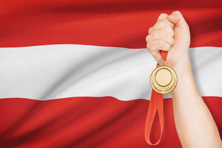 Sportsman holding gold medal with flag on background - Republic of Austriaの写真素材
