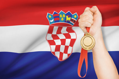 Sportsman holding gold medal with flag on background - Republic of Croatiaの写真素材