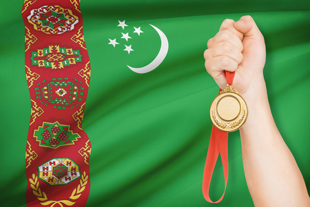 Sportsman holding gold medal with flag on background - Turkmenistanの写真素材