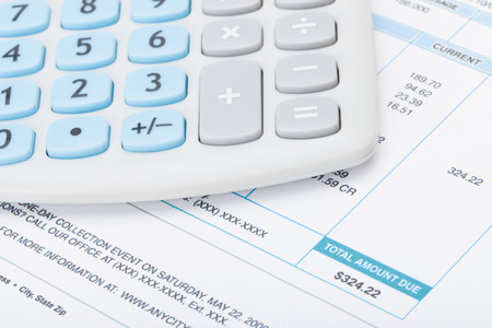 Calculator over utility bill - studio shotの写真素材