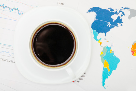 Coffee cup over world map and financial documents - view from topの写真素材
