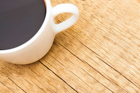 White ceramic coffee cup on wooden table - view from topの写真素材