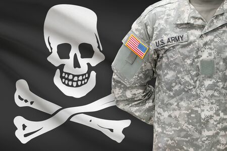 American soldier with flag on background - Jolly Roger - symbol of piracyの写真素材