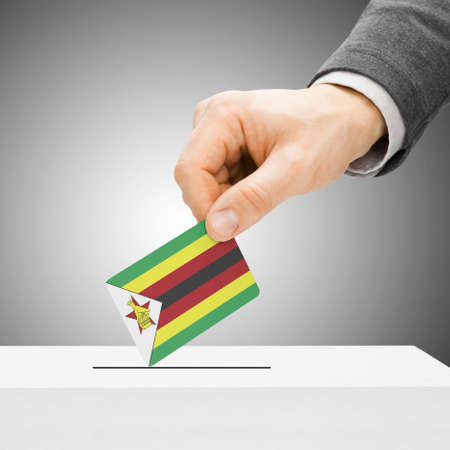 Voting concept - Male inserting flag into ballot box - Zimbabweの写真素材