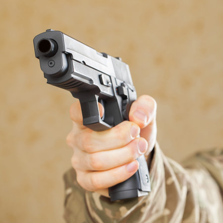 Man in black mask holding gun and ready to shot