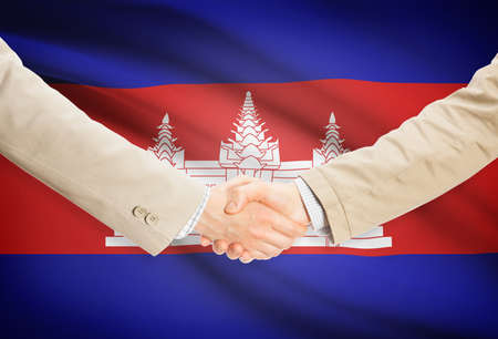 Businessmen shaking hands with Cambodia flag on backgroundの写真素材