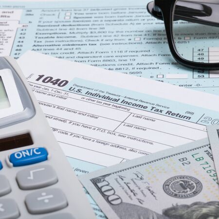 US 1040 Tax Form, calculator, glasses and dollars - close up shotの写真素材