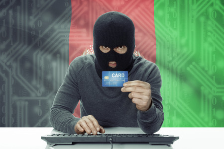 Dark-skinned hacker with credit card and flag on background - Afghanistanの写真素材