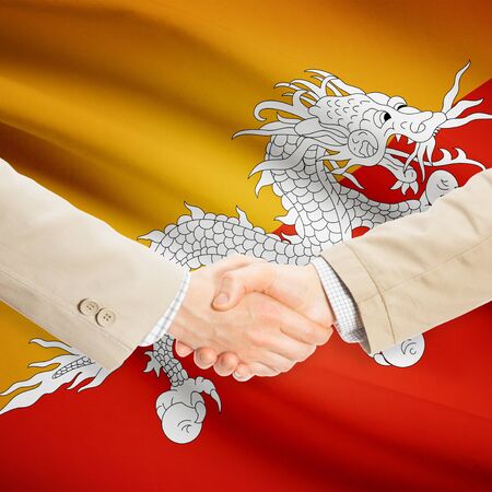 Businessmen shaking hands with flag on background - Bhutanの写真素材