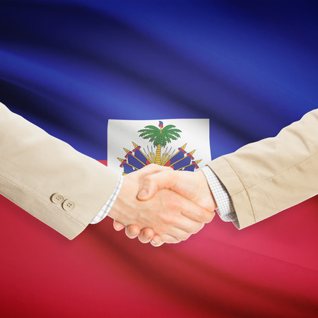 Businessmen shaking hands with flag on background - Haitiの写真素材