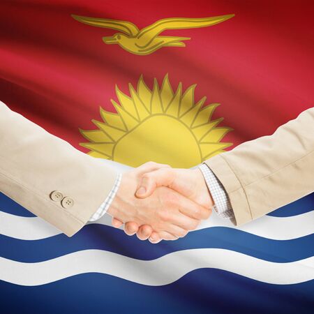 Businessmen shaking hands with flag on background - Kiribatiの写真素材