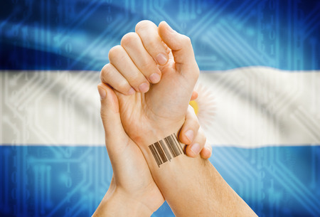 Barcode ID number on wrist of a human and national flag on background - Argentinaの写真素材