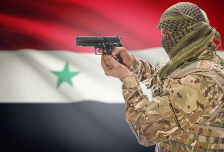 Male in muslim keffiyeh with gun in hand and national flag on background series - Syriaの写真素材