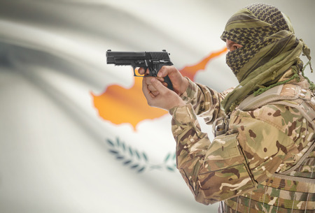 Male in muslim keffiyeh with gun in hand and national flag on background series - Cyprusの写真素材