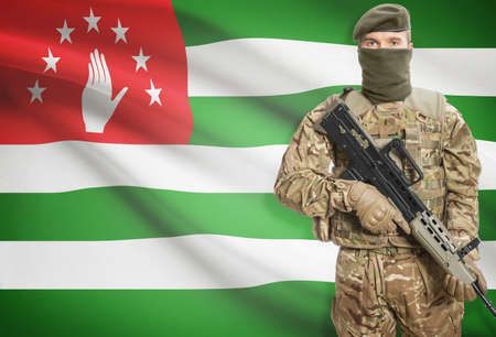 Soldier holding machine gun with national flag on background - Abkhaziaの写真素材