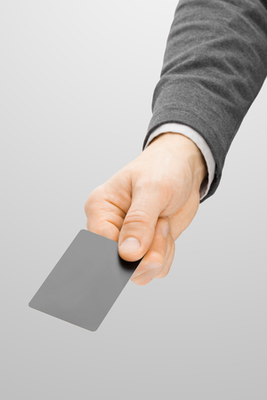Male holding in hand blank card of grey color - close up studio shotの写真素材