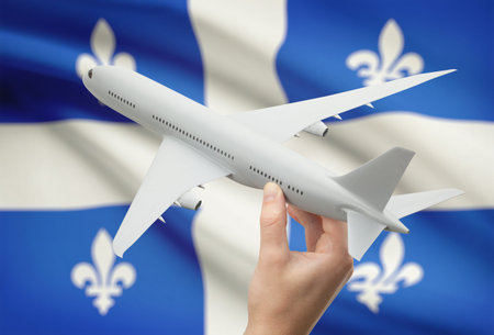 Airplane in hand with Canadian province or territory flag on background - Quebecの写真素材